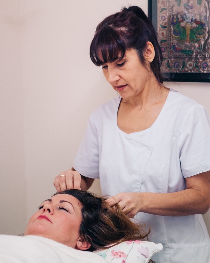 Gemma performing Indian Head Massage on a client lying on the treatment couch